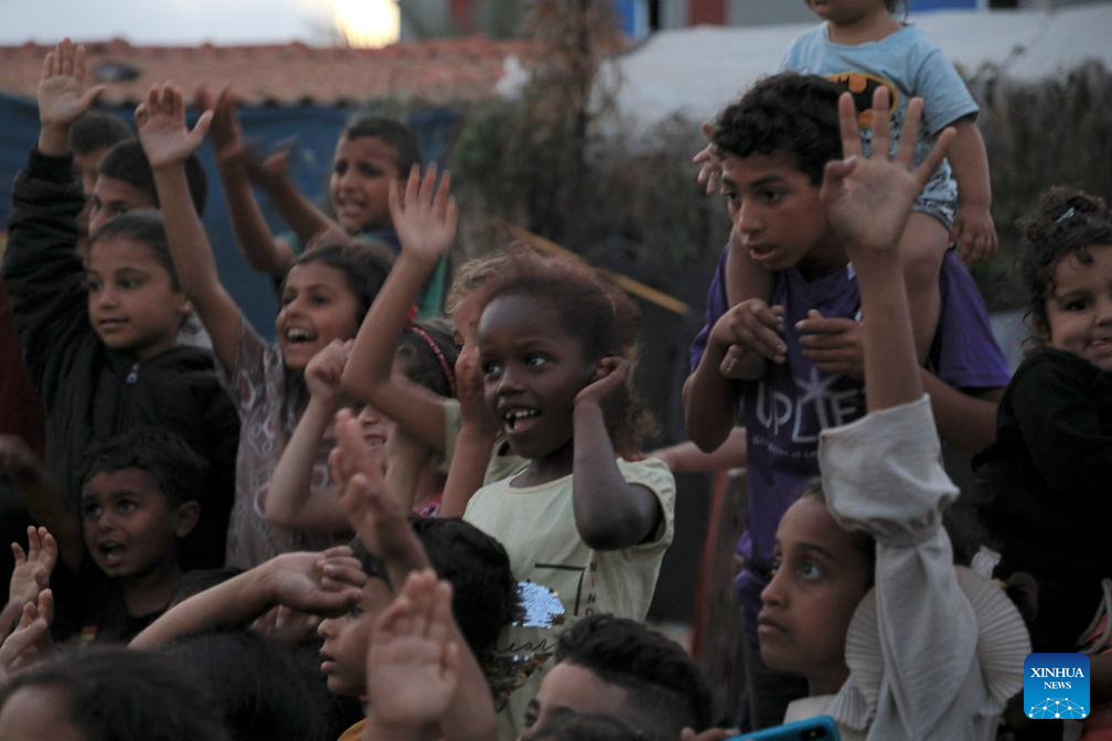 Children watch cartoon at temporary camp in Rafah